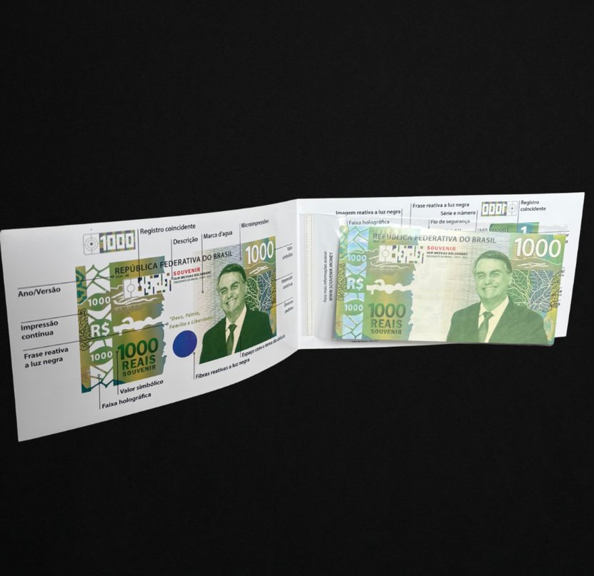 Encarte aberto da Cédula Colecionável Bolsonaro, com o mapa dos elementos de segurança e a peça no plástico protetor